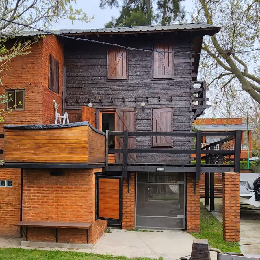 Cabaña de madera elevada con deck sobre la orilla del río en Isla Santiago.